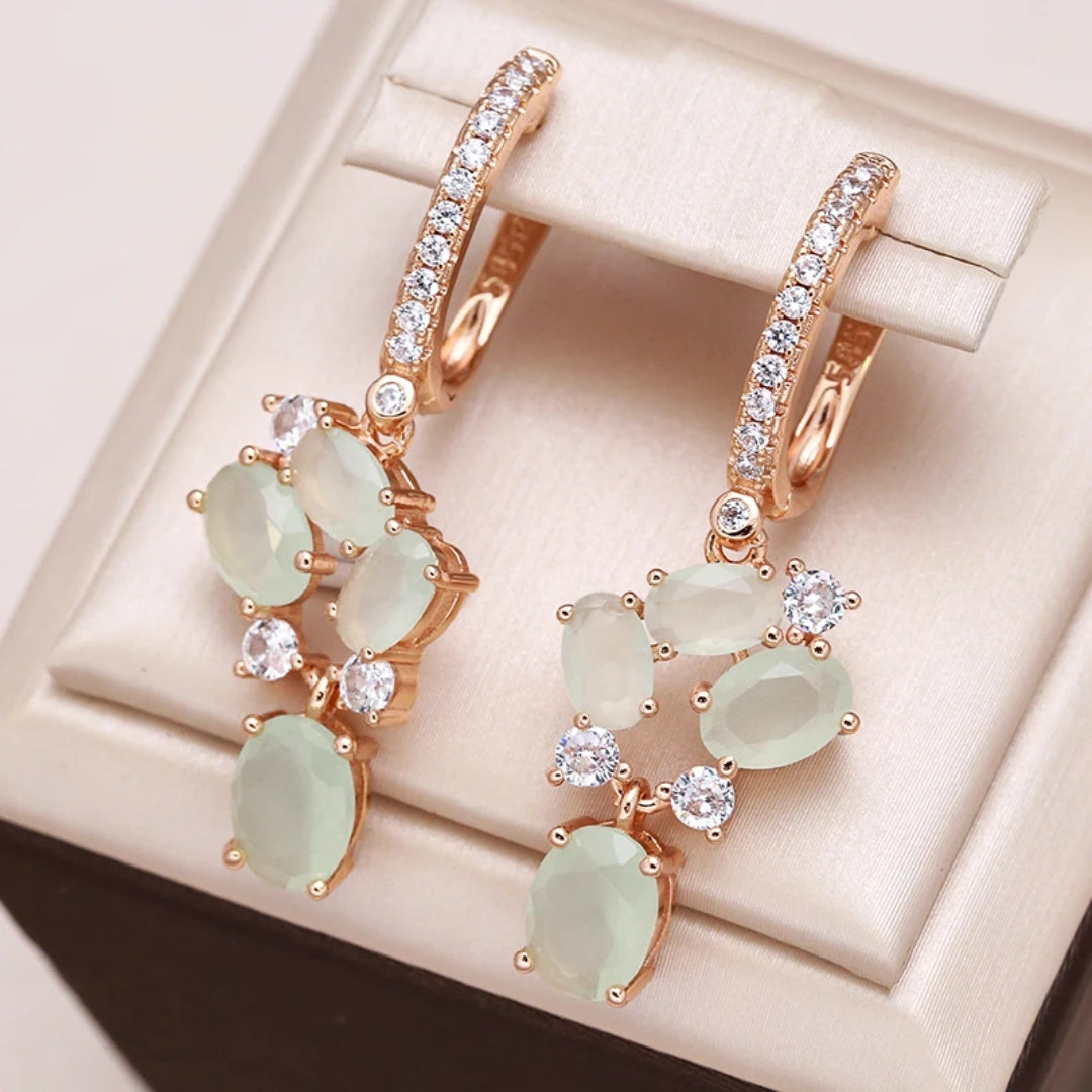 Amelia | Elegant gold earrings with sparkling green zirconia crystals.