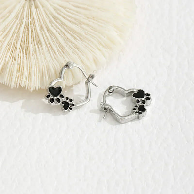 Olga | Silver-effect paw heart hoop earrings with black enamel.