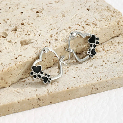 Olga | Silver-effect paw heart hoop earrings with black enamel.